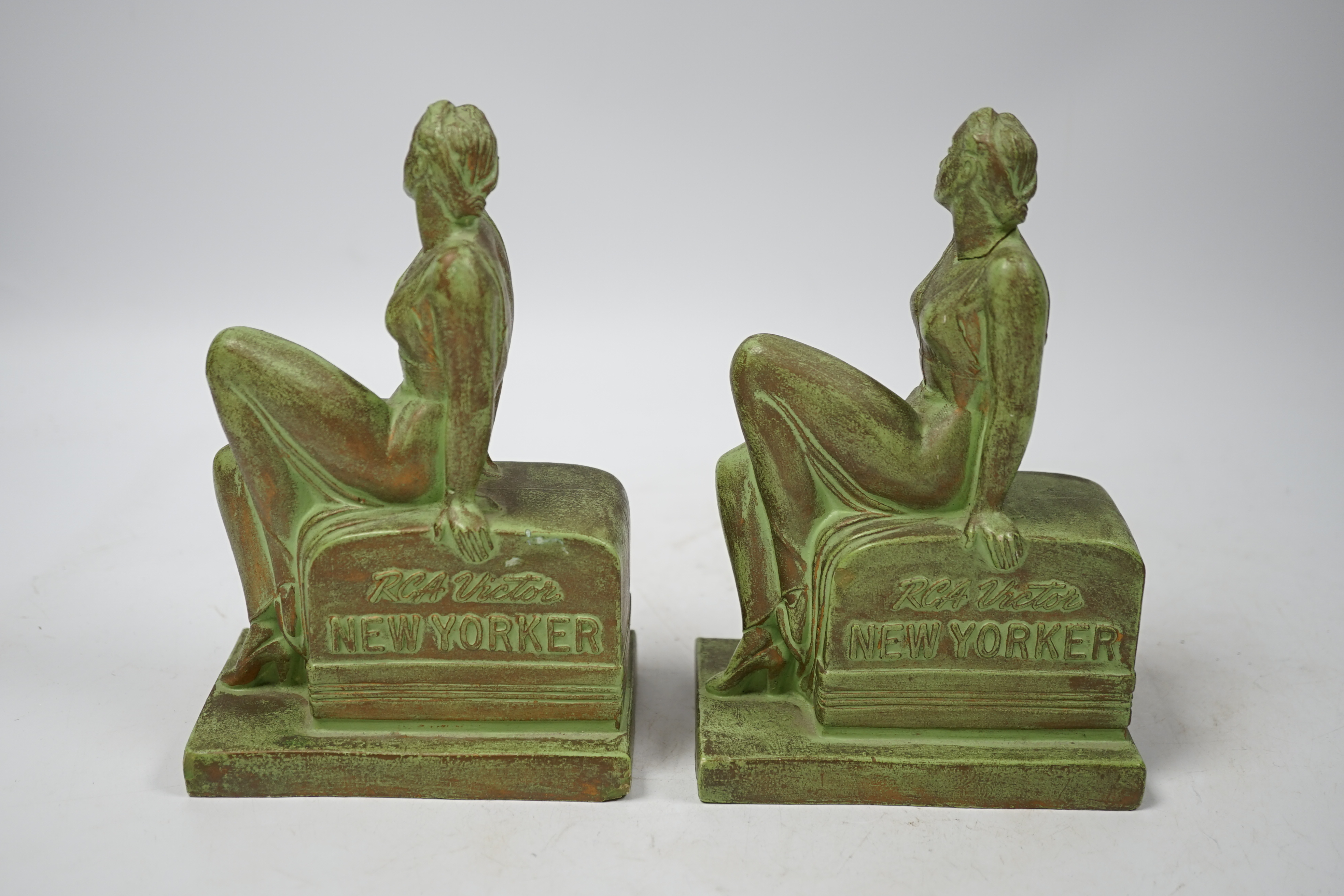 A pair of Art Deco RCA Victor bronzed ceramic ‘chalkwear’ bookends, in the form of a woman sitting on a 1930s radio, produced for the 1939 New York World Fair to promote the RCA Victor record label, 17cm high